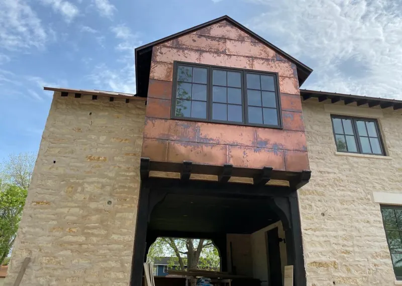 Copper metal panel facade on a stone building for Roof Repair in Elk City